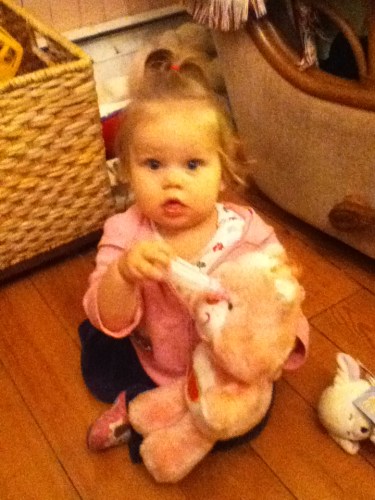 Keira feeding a bottle to her bear